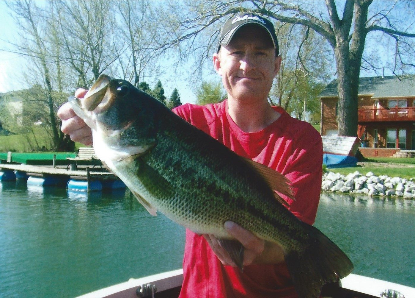 Man holding large fish by the water.