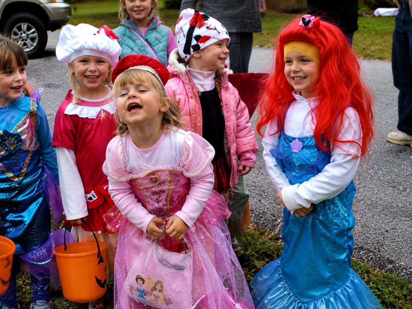 Children in colorful costumes laughing outdoors.