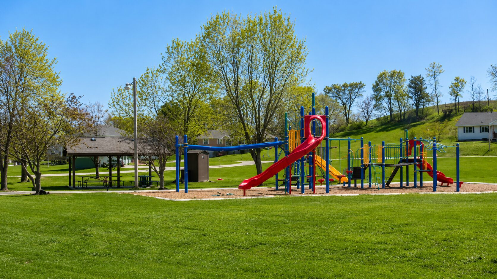 Playground with slides in a grassy park.